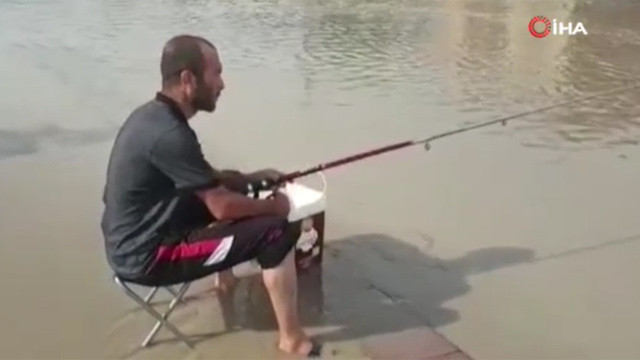 Ankara'da bir vatandaş göle dönen caddede balık yakaladı